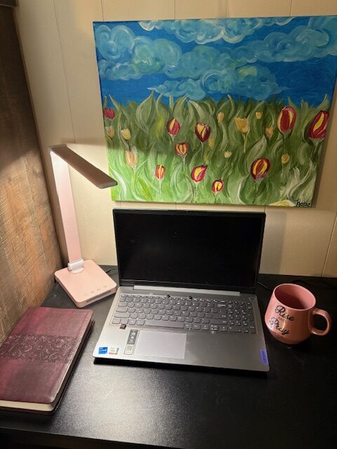 My Writing Desk A laptop on a wooden desk beside a closed Bible and a coffee mug that says ‘Rise and Pray’.